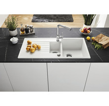 Keuken spoelbak met afdruiprek, mengkraan en diverse etenswaren op een werkblad