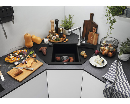 Hoekspoelbak met kraan in een moderne keuken met groenten en kruiden.