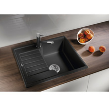 Zwarte spoelbak met afdruiprek en kraan op een werkblad.