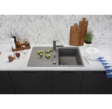 Spoelbak met kraan, groenten en keukengerei op een aanrecht