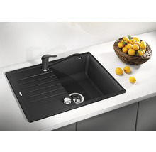 Granieten spoelbak met afdruiprek en kraan op een aanrecht met een citroenenmand