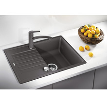 Spoelbak van silgranit met afdruiprek en kraan op een aanrecht.