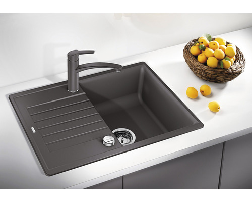 Spoelbak van silgranit met afdruiprek en kraan op een aanrecht.