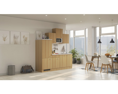 Complete kitchenette met kasten, gootsteen, magnetron en afzuigkap in een lichte, moderne ruimte.