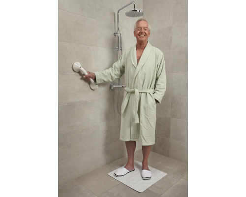 Man in badjas met handgreep, douchekop en douchemat in de badkamer