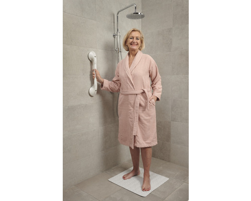 Douchescène met een vrouw die een handgreep en een douchemat gebruikt