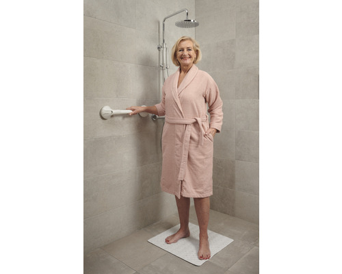 Vrouw in douche met handgreep en douchemat voor meer veiligheid