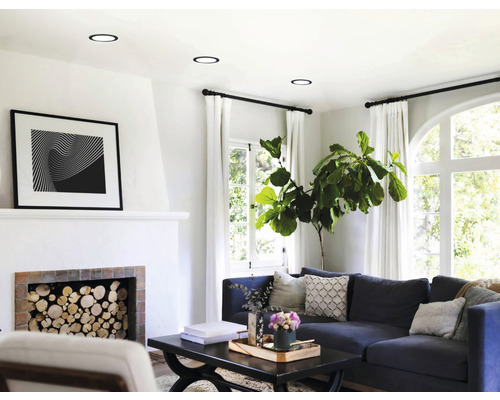 Lichte woonkamer met inbouwspots, open haard en bank