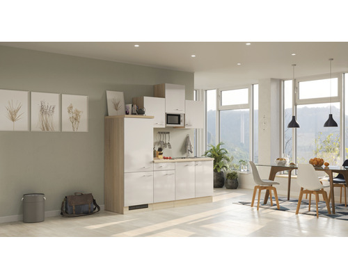 Compacte kitchenette in een lichte en moderne ruimte met eethoek en grote ramen.