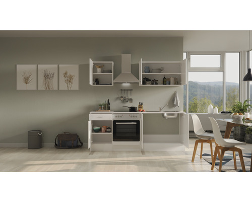Complete keuken met bovenkasten, afzuigkap, spoelbak en elektrisch fornuis in een lichte ruimte