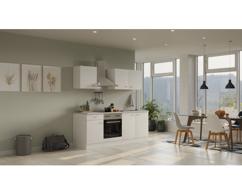 Lichte keuken met inbouwkasten, afzuigkap en eettafel in een moderne woonkamer.