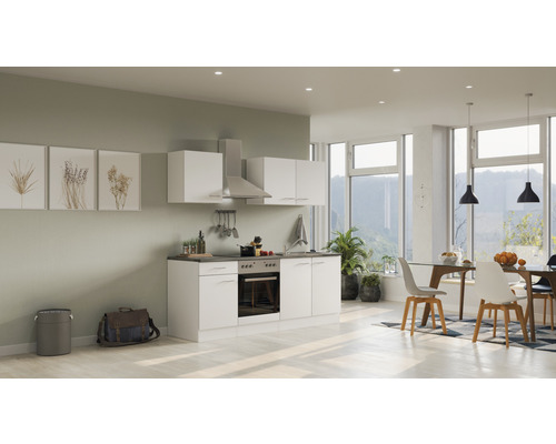 Lichte, moderne keuken met witte kasten en een eethoek in een ruime kamer.