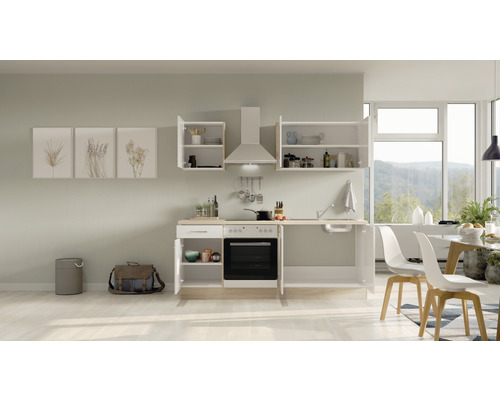 Moderne keuken met inbouwkasten, afzuigkap en eethoek in een lichte ruimte.