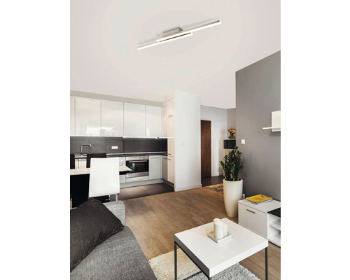 Moderne woonkamer met kitchenette en een lineaire plafondlamp.