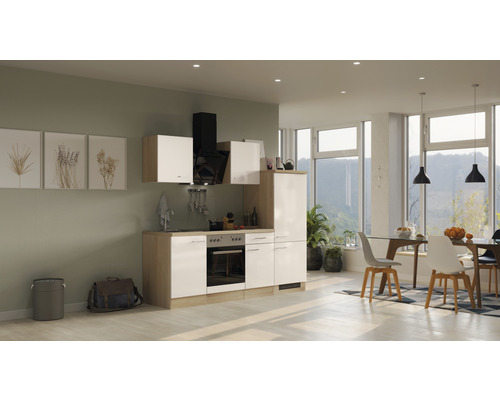 Lichte keuken met keukenkasten, afzuigkap en eettafel in een ruime kamer.