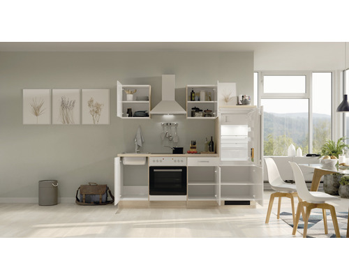 Inbouwkeuken met spoelbak, fornuis, afzuigkap en koelkast in een lichte ruimte.