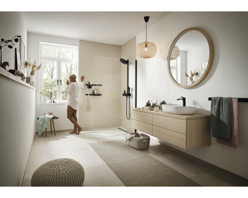 Lichte badkamer met douche, wastafel met spiegel en raam