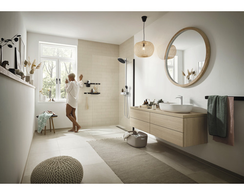 Lichte badkamer met douche, wastafel, spiegel en accessoires voor een moderne sfeer