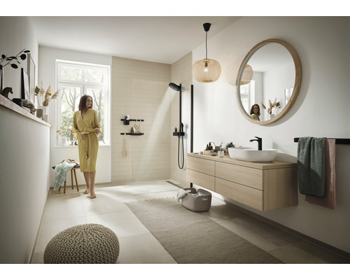 Lichte badkamer met douche, wastafel met spiegel, handdoekhouder en zitgelegenheid