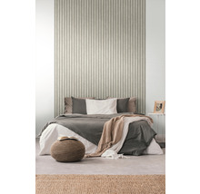 Slaapkamer met bed voor een wand met geribbeld behang