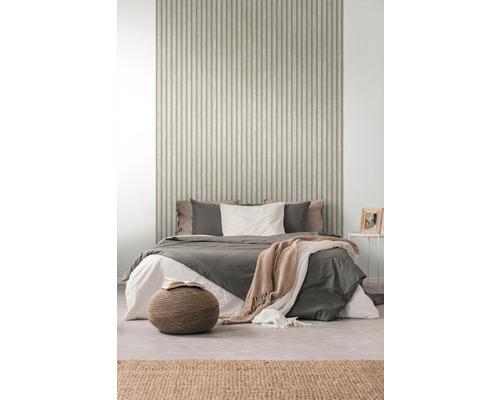 Slaapkamer met bed voor een wand met geribbeld behang