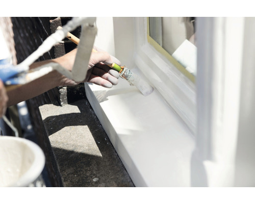 Persoon schildert raam met verfroller.