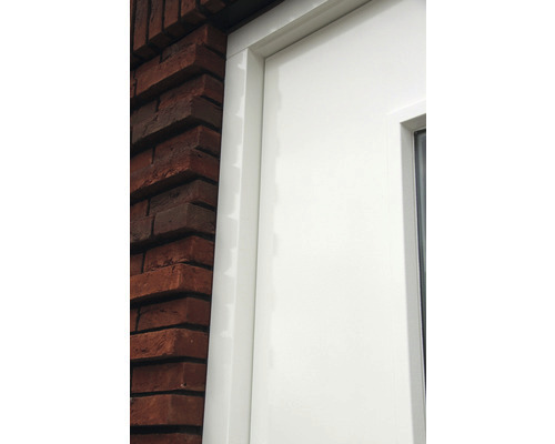 Detailopname van een witte deur naast een bakstenen muur