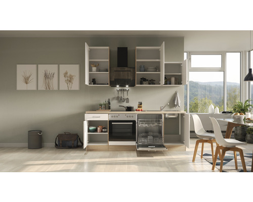 Keuken met apparatuur, bovenkasten en eettafel in lichte ruimte