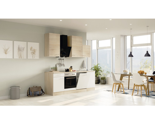 Lichte keuken met inbouwapparatuur, keukenkasten en eethoek in een ruime kamer.