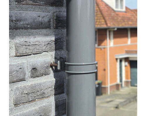 Kunststof regenpijp bevestigd aan een huismuur