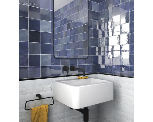 Badkamer met blauwe tegels, wastafel en spiegel