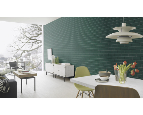 Woonkamer met groene bakstenen muur, eettafel en raam