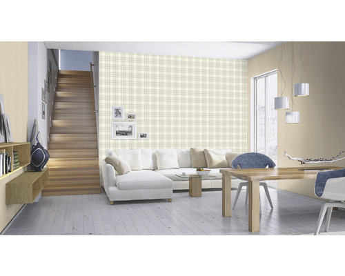 Woonkamer met trap, bank, eettafel en wandbekleding met ruitpatroon.