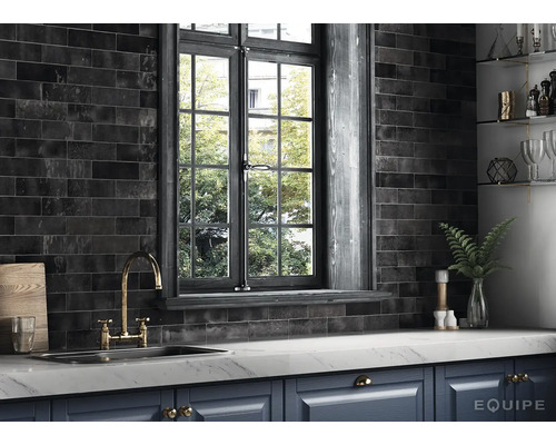 Keukenscène met zwarte tegels, gootsteen, kraan en raam