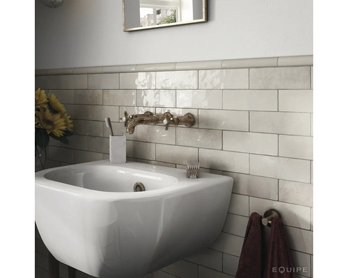 Badkamer met wastafel, kraan en wandtegels in retrostijl