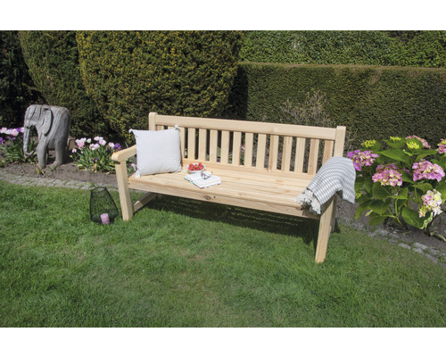 Tuinscene met houten bank, kussen en decoratie