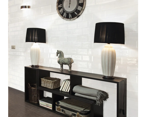 Woonkamer met zwarte rekken, tafellampen en witte wandtegels in retrostijl