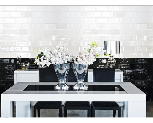 Eetkamer met eettafel, stoelen, zilveren vazen en tegelwand