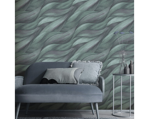 Woonkamer met bank, bijzettafel en groen behang met golfpatroon