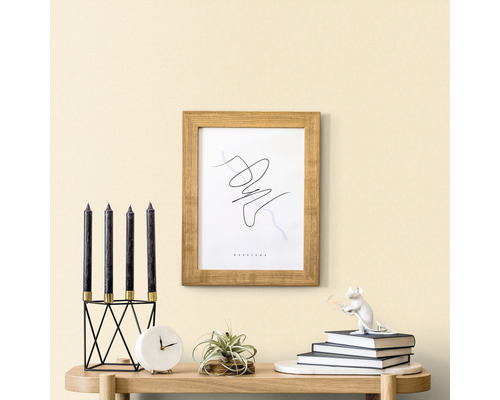 Decoratieve scène met kaarsen, klok, plant, lijst en decoratief figuur op een tafel