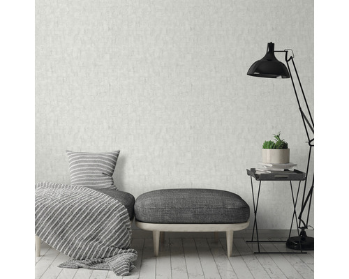 Woonkamer met patroonbehang, zitmogelijkheid, kussen, deken en vloerlamp