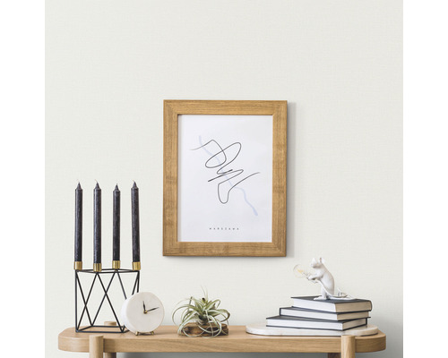 Decoratieve scène met kaarsen, fotolijst en accessoires op een tafel.