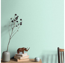 Decoratieve wanddecoratie met vaas, decoratie en boeken op een tafel voor een wand