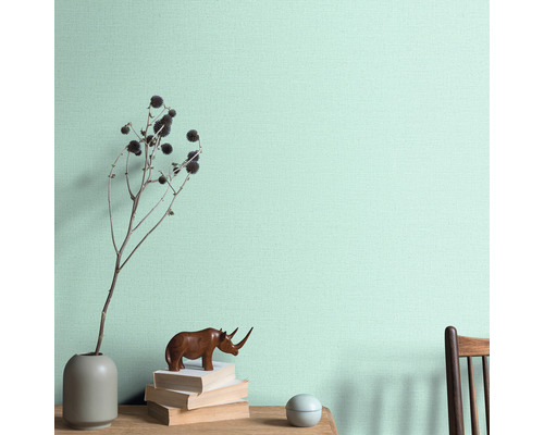 Decoratieve wanddecoratie met vaas, decoratie en boeken op een tafel voor een wand