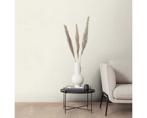 Decoratieve veren in een witte vaas op een zwarte bijzettafel naast een bank