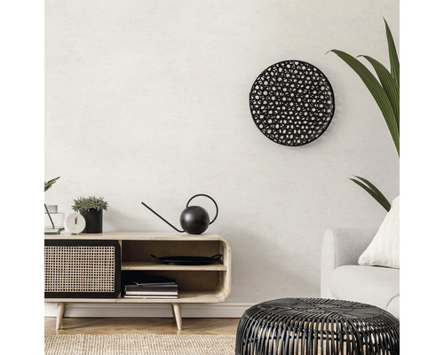 Woonkamer met dressoir, ronde wanddecoratie en rieten tafel