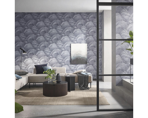 Woonkamer met patroonbehang, bank, tafel en decoraties voor een modern interieur.