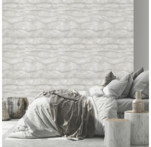 Slaapkamer met bed voor een lichtkleurig behang met golfpatroon