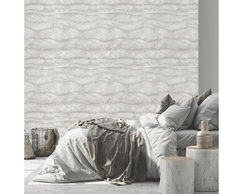 Slaapkamer met bed voor een lichtkleurig behang met golfpatroon