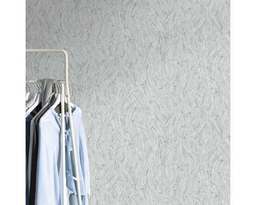 Close-up van een gestructureerd behang met kledingrek en kledingstukken in de kamer